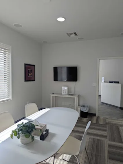 Family meeting room with a table, chairs and wall-mounted screen