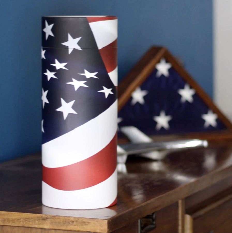 Scattering tube with an American flag design beside a folded flag case
