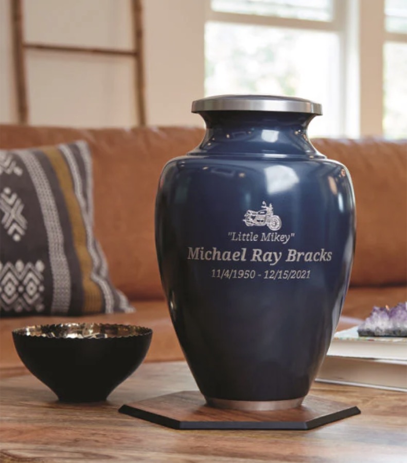 Navy urn with a personalized engraving on a coffee table